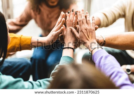 Young multiracial group stacking hands together- Happy diverse friends united at community table having fun- youth Millennial students giving strength motivation- Human resources teamwork concept Royalty-Free Stock Photo #2311870625
