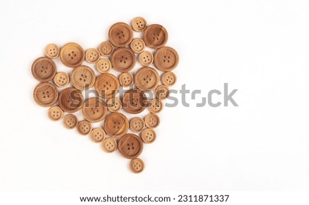 Heart from wooden buttons on a white background. Symbol of love