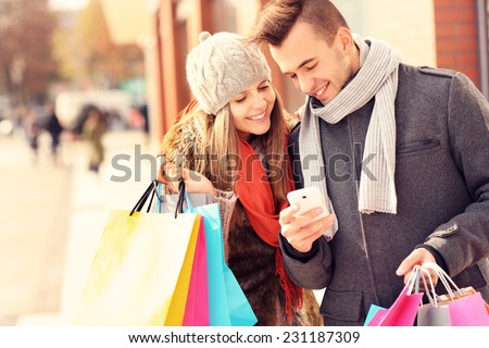 A picture of a couple shopping with smartphone in the city