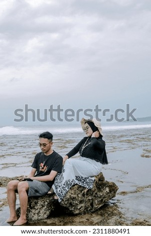 romantic vacation of a young couple on the beach in black t-shirts