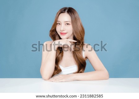 Young Asian beauty woman curly long hair with korean makeup style on face and perfect clean skin on isolated blue background. Facial treatment, Cosmetology, plastic surgery. Royalty-Free Stock Photo #2311882585