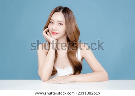 Young Asian beauty woman curly long hair with korean makeup style on face and perfect clean skin on isolated blue background. Facial treatment, Cosmetology, plastic surgery. Royalty-Free Stock Photo #2311882619