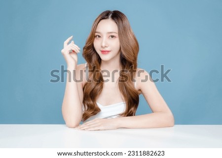 Young Asian beauty woman curly long hair with korean makeup style on face and perfect clean skin on isolated blue background. Facial treatment, Cosmetology, plastic surgery. Royalty-Free Stock Photo #2311882623