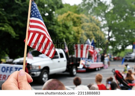 Waving an American flag at the Independence Day Parade on the 4th of July
 Royalty-Free Stock Photo #2311888883