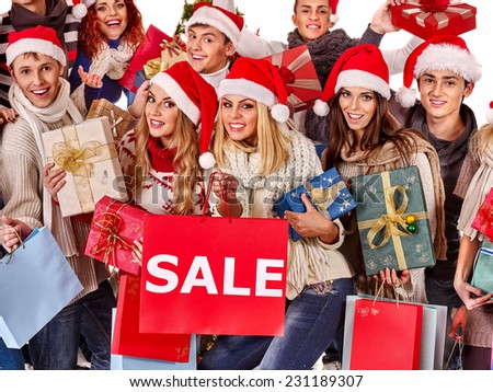 Women in Santa hat holding sign saying sale and gift box.