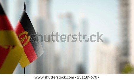 Small flags of the GDR on an abstract blurry background.