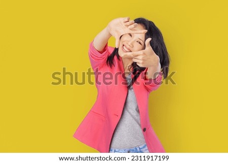 Beautiful smiling woman making frame gesture. Creative photoshoot or blogging concept