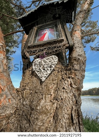 Kalety, Poland, May 22, 2023: Spider web on a forest chapel with a picture of Merciful Jesus. The inscription in Polish: "Jesus, I trust in You"
