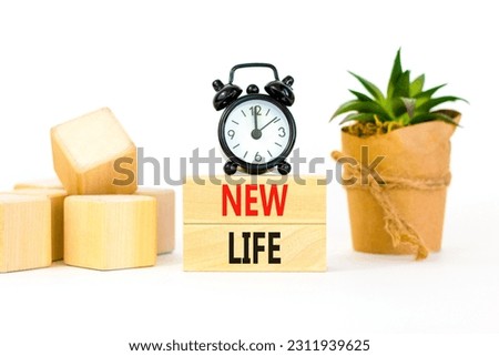 New life symbol. Concept words New life on wooden blocks on a beautiful white background. Black alarm clock. Business, support, motivation, psychological and new life concept. Copy space.