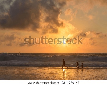 Sunset on the beach and two people walking