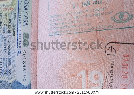 close up pages Russian Federation foreign passport with European Ireland visa, border stamps, permits to enter countries, concept of traveling around the world, traveler's travel document