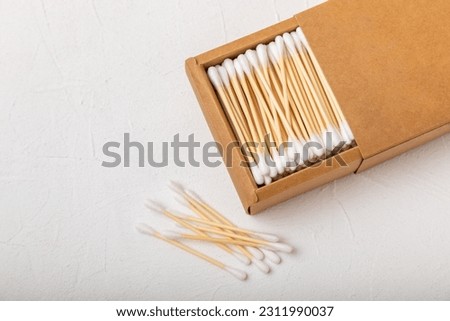 White cotton swabs on concrete texture background. Cotton buds. Bamboo cotton buds. Eco friendly. Hygienic cotton swabs for ears. Place for text. Place to copy. Royalty-Free Stock Photo #2311990037