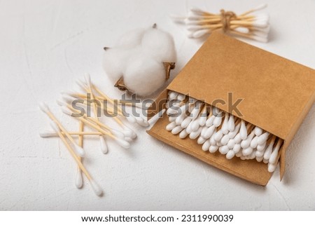 White cotton swabs on concrete texture background. Cotton buds. Bamboo cotton buds. Eco friendly. Hygienic cotton swabs for ears. Place for text. Place to copy. Royalty-Free Stock Photo #2311990039