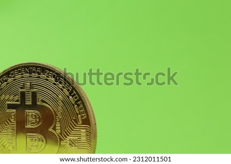 Close-up of Bitcoin cryptocurrency on green background. Business background. Gold shining BTC cryptocurrency coin.