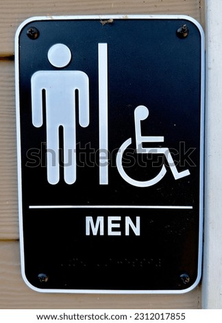 Men's bathroom sign on the wall outside of facility