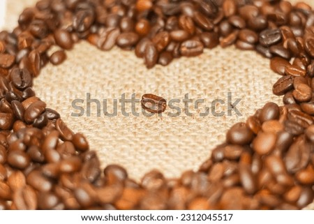 One coffee beans put on center of a lot of coffee are spread on the table like a heart picture.text or background or copy space.