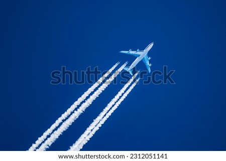 Sharp telephoto close-up of jet plane aircraft with contrails cruising from Anchorage to Dallas, altitude AGL 35,000 feet, ground speed 476 knots. Royalty-Free Stock Photo #2312051141