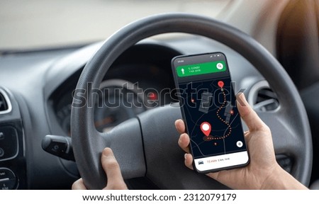 Title: Use the mobile phone in map search mode, inside the black car. Turn on the online location navigator to the destination. highway traffic concept Royalty-Free Stock Photo #2312079179