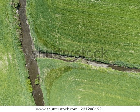 drone view of a stream and green grass in the countryside