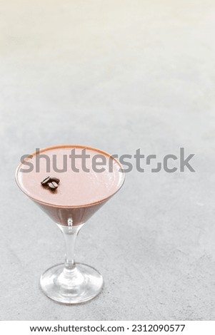 Coffee Panna Cotta in a martini glass. Light grey background. Copy space