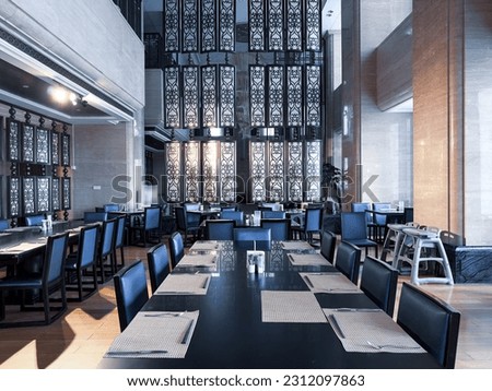 Restaurant interior, part of hotel, Asian Zen and Chinese style design.The table has been set with  knives and forks, and white China plates.