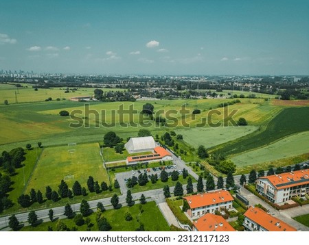 Agricultural area and green wavy fields on a sunny day. Aerial photography, drone shot from above. Location: Italy, Lombardy, Europe. Artistic wallpaper. The beauty of the earth.