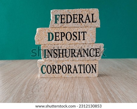 FDIC federal deposit insurance corporation symbol Concept words FDIC federal deposit insurance corporation on brick blocks on green background.