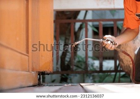 man chose to use exterminate chemicals Termites that are not toxic to humans are mixed with water in a tank for spraying Exterminate termites allow young men to spray termites themselves by himself Royalty-Free Stock Photo #2312136037