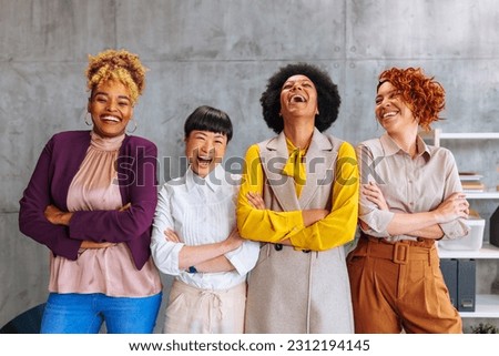 Group photo of successful diverse female business team laughing in the office.