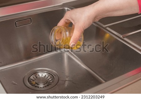 Old cooking oil poured into the kitchen waste, clogging the waste sink with oil Royalty-Free Stock Photo #2312203249