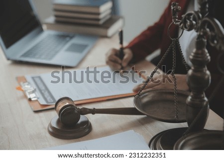 Justice and law concept.Male judge in a courtroom with the gavel, working with, computer and docking keyboard, eyeglasses, on table in morning light Royalty-Free Stock Photo #2312232351