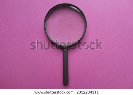 black frame a magnifying glass isolate on a colored paper purple background