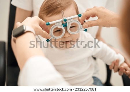Pediatric eye doctor preparing child for visual acuity test Royalty-Free Stock Photo #2312257081