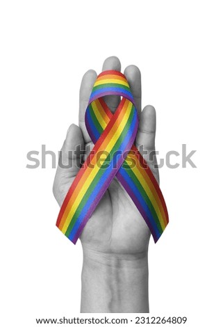 LGBT, LGBTQ for gay pride month and International Day Against Homophobia, Transphobia and Biphobia with rainbow ribbon flag awareness on hand isolated with clipping path on white background Royalty-Free Stock Photo #2312264809