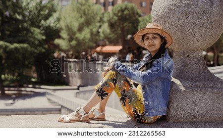 Young tourist sitting on bridge relaxing on summer afternoon