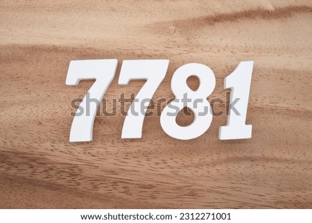 White number 7781 on a brown and light brown wooden background.
