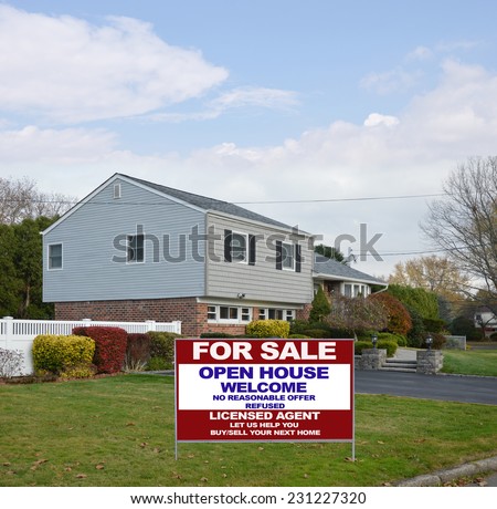Real estate for sale open house welcome sign on lawn of suburban high ranch style home autumn season residential neighborhood blue sky clouds USA