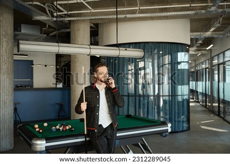 Smiling man having phone conversation in modern room Royalty-Free Stock Photo #2312289045