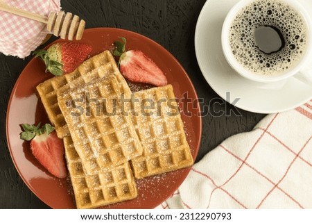 Fresh waffles on the table, freshly baked Belgian waffles. Wooden background, copy space. Delicious homemade Belgian waffles with syrup or honey, sweet summer healthy breakfast