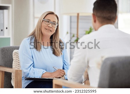 Woman, psychiatrist and patient talking during consultation in the clinic or psychologist listen to a man at the office. Mental health, female therapist and conversation or guy for appointment Royalty-Free Stock Photo #2312325595
