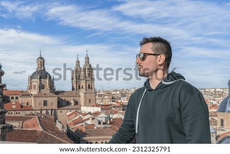 Boy with sunglasses taking a profile picture overlooking the city of Salamanca.