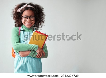 School, portrait of child student with books for knowledge, education and studying in a studio. Happy, smile and young smart girl kid with glasses for reading by a white background with mockup space. Royalty-Free Stock Photo #2312326739