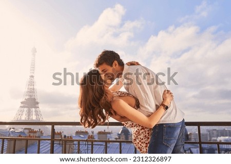 Paris, love and couple together for a kiss, romantic time or balcony of apartment, hotel with Eiffel Tower in background. Partner, woman and man in France for vacation, travel or honeymoon holiday