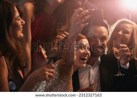Selfie, party and new year with friends in a nightclub posing for photograph of celebration together. Champagne, toast and nightlife with a group of people taking a picture in a club while dancing