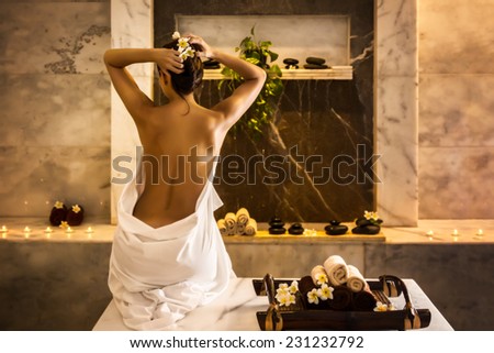 Beautiful girl in hammam. Tray with towels and flowers. Royalty-Free Stock Photo #231232792