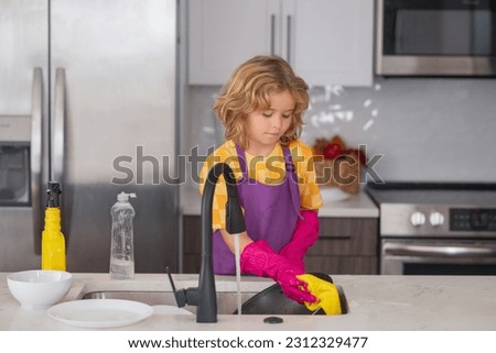 Cleaning house. Little housekeeper. Child washing and wiping dishes in kitchen. American kid learning domestic chores at home. Kid cleaning to help parents with housework routine. Royalty-Free Stock Photo #2312329477