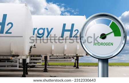Hydrogen gauge with tree colors - gray, blue and green on a background of hydrogen tank trailers. Green fuel concept
