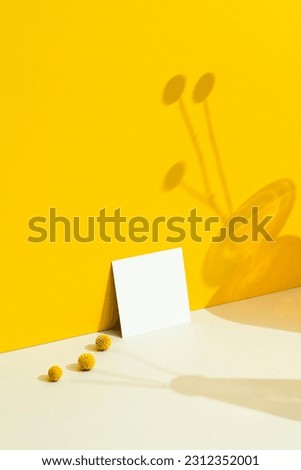 Square shape business card mockup on yellow background with floral shadows.