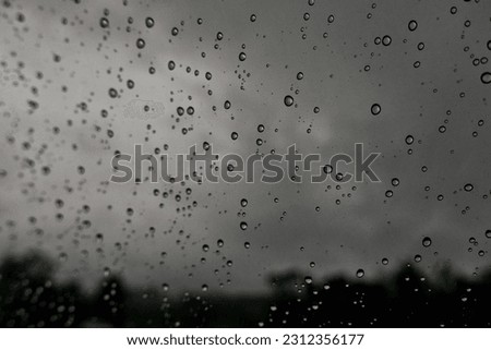 The abstract shot of rain drops on the glass mirror.