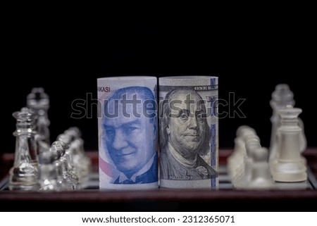 100 dollars and 100 Turkish lira , Economic war on the chessboard. Fictional shooting and custom focus adjustable. Royalty-Free Stock Photo #2312365071